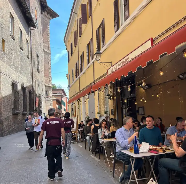 Le Moline busy terrace in via delle Moline, outdoor tables under the red awning