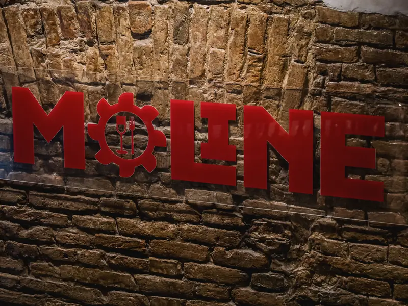 Insegna Le Moline in rosso sul muro di mattoni dell'osteria, Bologna
