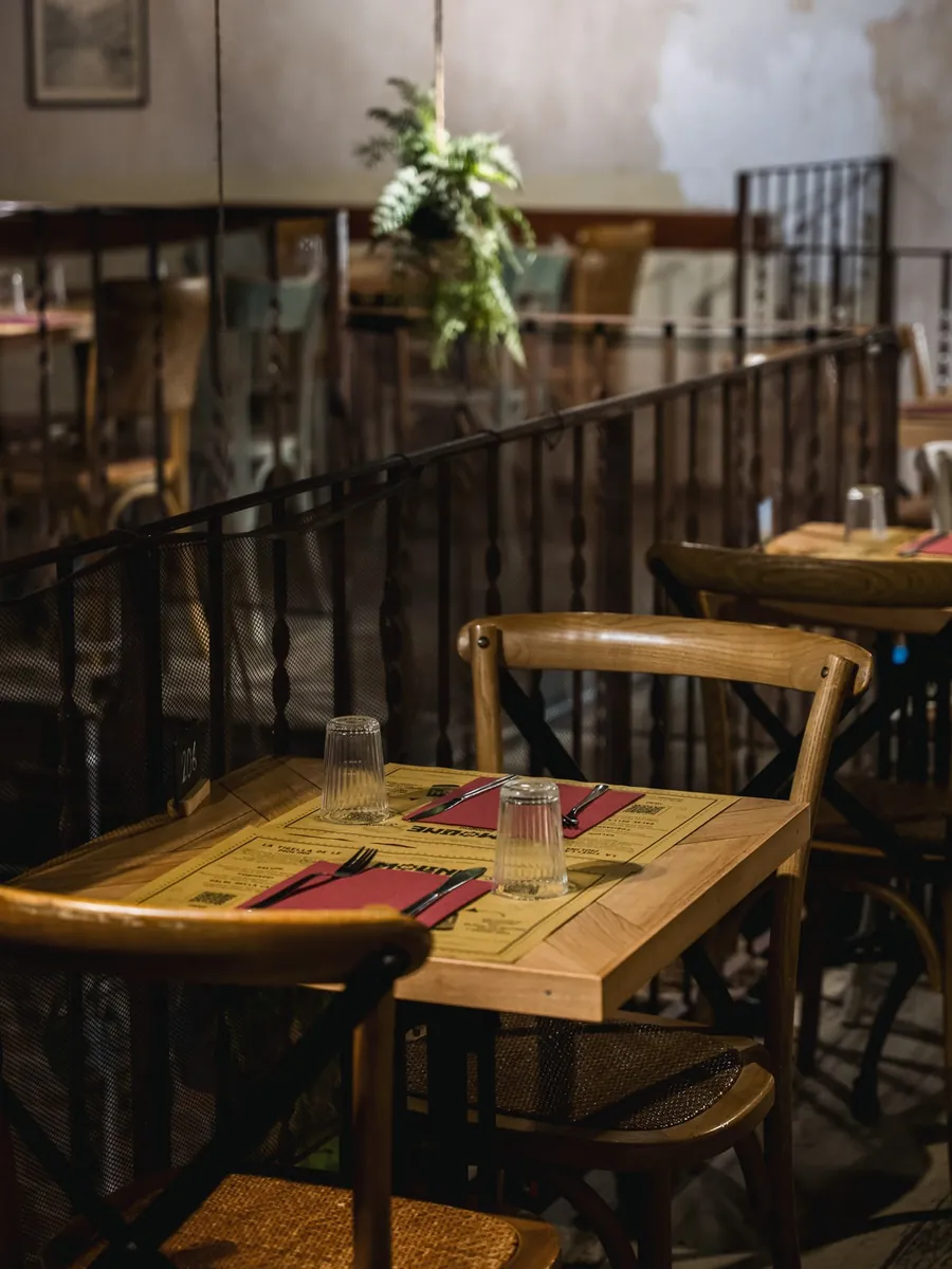 Sala interna de Le Moline con tavoli in legno, sedie in paglia e piante