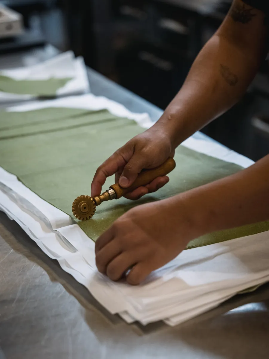 Green spinach pasta sheet rolled by hand in Le Moline kitchen