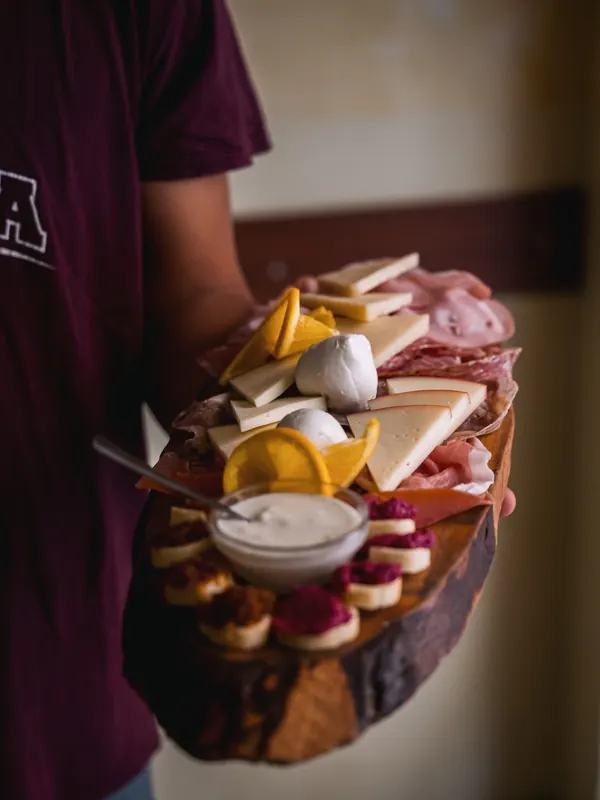 Le Moline waiter bringing a board of cured meats and cheeses to the table